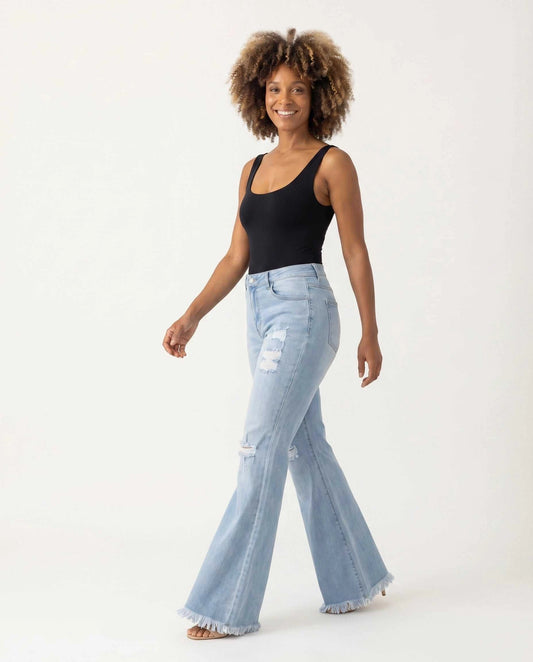 Zara wearing Denim Pants with Flare & Fringe — walking stride view, black bodysuit styling